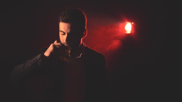 4k video muže pití alkoholu a kouření na tmavém pozadí. — Stock video
