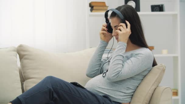 4k видео беременной женщины, слушающей музыку. — стоковое видео