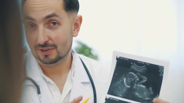 4k video lékaře mluvit o ultrazvuku výsledky s těhotnou ženou. — Stock video