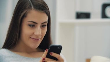 Beyaz koltukta telefonu olan hamile bir kadının 4k yavaş çekim videosu..
