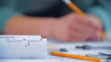 Sarı kalemle çalışan bulanık kadın elinin 4K videosu..