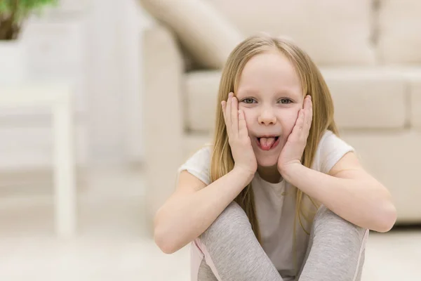 Foto de menina loira pequena mostrando língua. — Fotografia de Stock