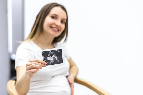 Foto einer lächelnden Schwangeren mit Ultraschall-Ergebnis. — Stockfoto