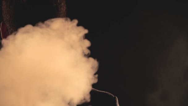 4k βίντεο αργής κίνησης του ανθρώπου που γυρίζει γύρω στον καπνό σε μαύρο φόντο. — Αρχείο Βίντεο