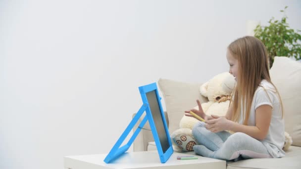 Дитяча дівчина малює на білій дошці вдома в 4k уповільнення відео . — стокове відео