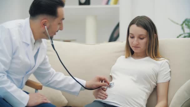 청진기를 가진 임신부를 진찰하고 있는 의사의 느린 동작 비디오 4k. — 비디오