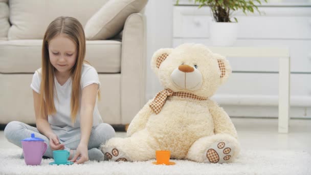 4k video of little girl playing with teddy bear sitting on the floor. — Stock Video