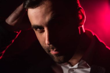 Arka planda duran adamın ve pembe ışığın yakın fotoğrafını çek..