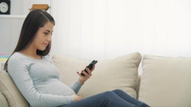 Kanepede hamile bir kadının selfie çekerken 4k yavaş çekim videosu..