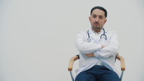 Laboratuvar önlüğü giymiş bir doktorun sandalyeye oturduğu 4K yavaş çekim videosu..