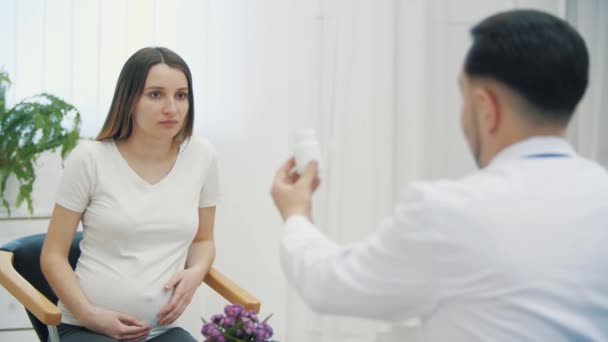 4k-Video eines Arztes, der einer schwangeren Frau ein Medikament gibt, sich aber weigert, es einzunehmen. — Stockvideo