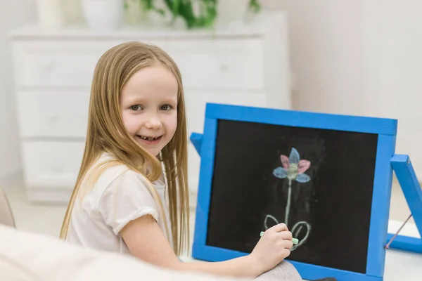 Foto Ragazza Bionda Che Disegna Fiore Sulla Lavagna Bianca Concetto — Foto Stock