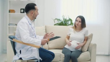 Hamile bir kadının doktorla konuştuğu 4K video. Doktoru ziyaret etme kavramı.