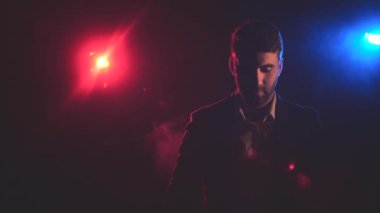 Mavi ve pembe ışıklarla duman içindeki adamın 4K yavaş çekim videosu. Dumanlı insan kavramı.