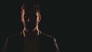 4k, gölge ve duman içindeki erkek yüzünün yavaş çekim videosunu kapat. Gölgede kalan insan kavramı.