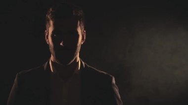 4k close up slow motion video of male face in shadow and smoke. Concept of man and math symbols.