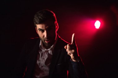 Arka planda parmak ve pembe ışık gösteren bir adam fotoğrafı. İnsan kavramı.