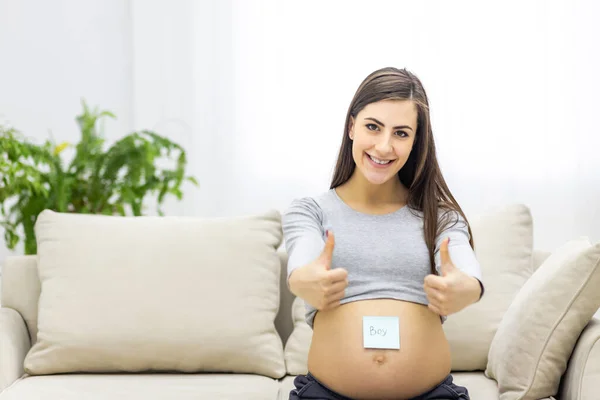 Photo Pregnant Woman Blue Paper Her Stomach Showing Thumb Ups — Stockfoto