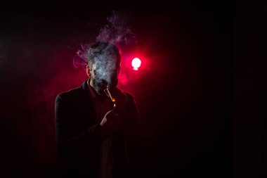 Pembe arka planda sigara içen bir adamın fotoğrafı. Sigara içme kavramı.