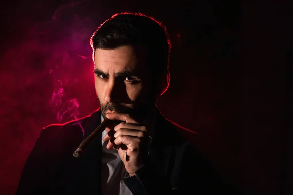 Photo of man smoking in the darkness. Concept of smoking man.