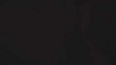 4K yavaş çekim, duman ve karanlığın içindeki adamın yaratıcı videosu. Moda ve tarz kavramı.