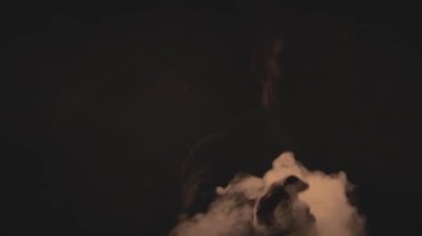 4K yavaş çekim, duman ve karanlığın içindeki adamın yaratıcı videosu. Moda ve tarz kavramı.