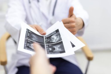 Photo of pregnant woman visiting her doctor without faces. Concept of pregnant woman.