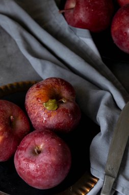 Masada kırmızı elmalar var. Karanlık ruh hali yemek fotoğrafçılığı
