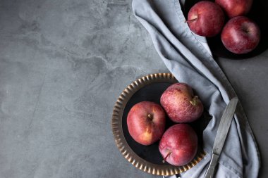 Masada kırmızı elmalar var. Karanlık ruh hali yemek fotoğrafçılığı