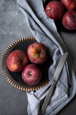 Masada kırmızı elmalar var. Karanlık ruh hali yemek fotoğrafçılığı