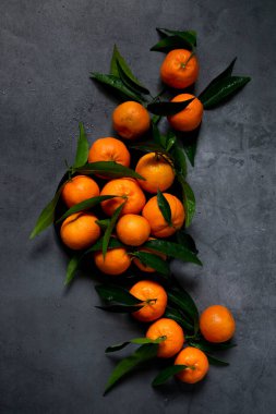 Koyu arkaplanda taze çiğ mandalina, sağlıklı besin maddeleri.