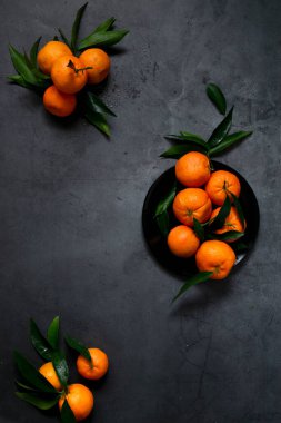 Koyu arkaplanda taze çiğ mandalina, sağlıklı besin maddeleri.