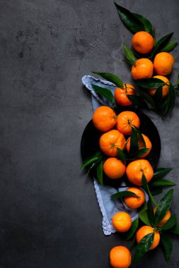 Koyu arkaplanda taze çiğ mandalina, sağlıklı besin maddeleri.