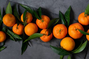 Koyu arkaplanda taze çiğ mandalina, sağlıklı besin maddeleri.