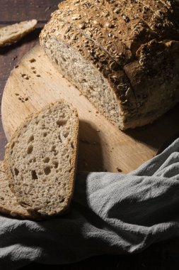 Köy ahşap masa üzerinde tohumlu dilimlenmiş toptan ekmek.