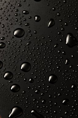 Siyah metal su, karanlık yansıtıcı yüzeye düşer.