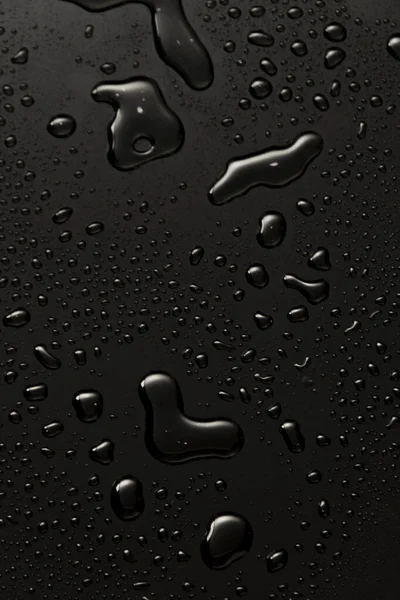 Siyah metal su, karanlık yansıtıcı yüzeye düşer.