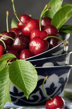 Antika tabaklarda taze toplanmış kirazlar, koyu yiyecek fotoğrafçılığı.