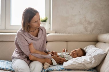 Küçük çocuk yüksek sıcaklıktan dolayı ağlar. Yaşamın ilk yılı. Evde yüksek ateşi olan hasta bir çocuk var.