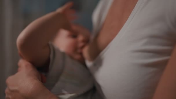 Giovane bella madre, che allatta il suo neonato di notte, luce fioca. Mamma allattamento infantile — Video Stock