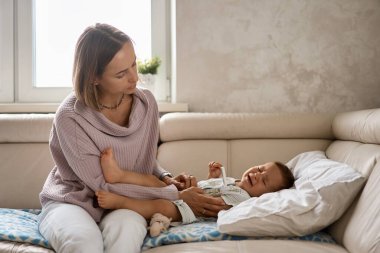 Küçük çocuk yüksek sıcaklıktan dolayı ağlar. Yaşamın ilk yılı. Evde yüksek ateşi olan hasta bir çocuk var.