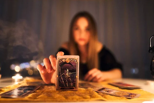 Cajero de la fortuna manos femeninas y cartas del tarot. — Foto de Stock