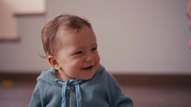 Anne ve küçük oğlu evde eğleniyor ve oynuyorlar. 1 yaşındaki küçük bir çocuk evde annesiyle oynuyor ve yerde oturuyor. Mutlular, gülümsüyorlar ve gülüyorlar..