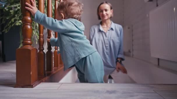 Matka z małym chłopcem na drewnianych schodach w domu — Wideo stockowe