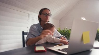 Kapatma sırasında ev ofisinden cep telefonuyla konuşan bir kadın not yazıyor.