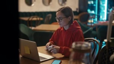 Kafe 'de dizüstü bilgisayarda çalışan beyaz bir kadın ya da blogcu. Teknoloji kullanan üniversite öğrencisi, çevrimiçi eğitim, serbest çalışma.