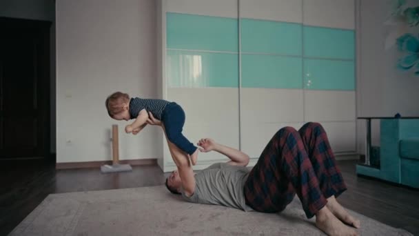 Père heureux jouant avec son fils sur le sol à la maison. — Video