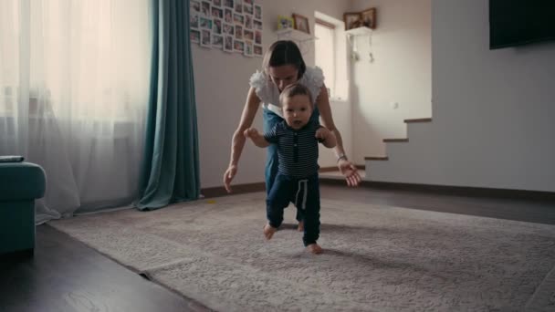Netter lächelnder kleiner Junge, der laufen lernt. Babys erste Schritte. Baby macht seine ersten Schritte. — Stockvideo