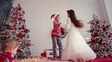 Yatakta yastıkla zıplayan sevimli çocuklar, Noel sabahı, çocuk partileri. Noel çok eğlenceli..