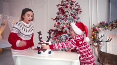 Anne ve oğlu Noel pastasının yanında oturuyorlar. Çocuk pasta yemek için Noel 'i bekliyor.